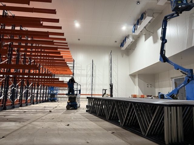 Chambre froide en cours d'équipement : racks de stockage, évaporateurs fixés en hauteur