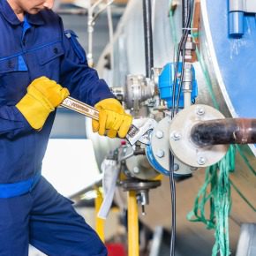 Technicien effectuant une opération de maintenance industrielle sur une machine | YLA Engineering